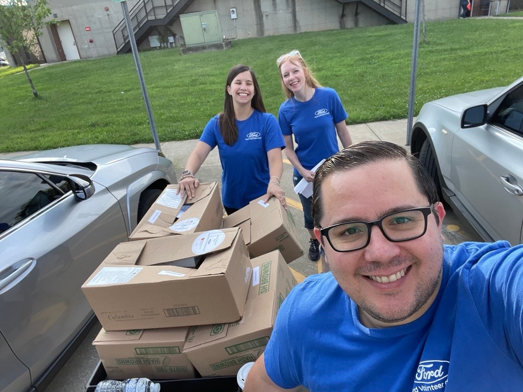 Alex Buznego, senior manager of mobility programs at Ford Philanthropy, helps load up donations as part of Project DASH.